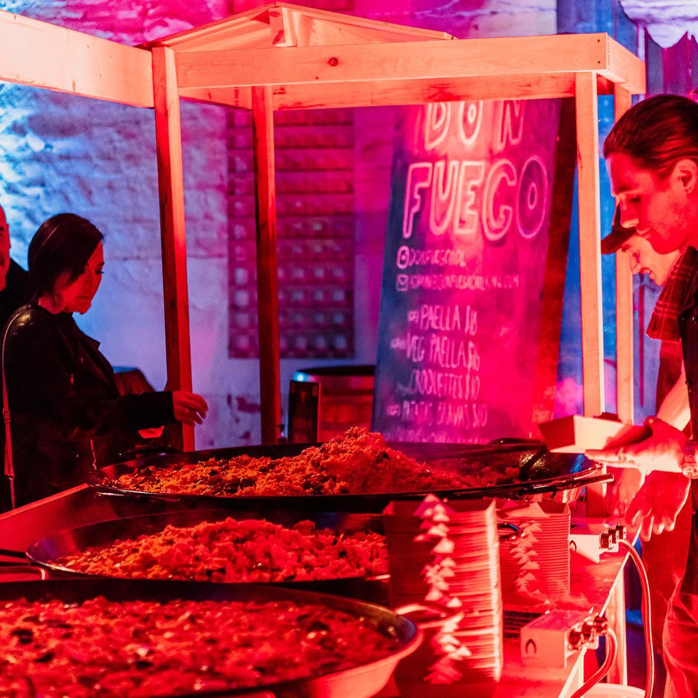 Paella pans cooking at a night event