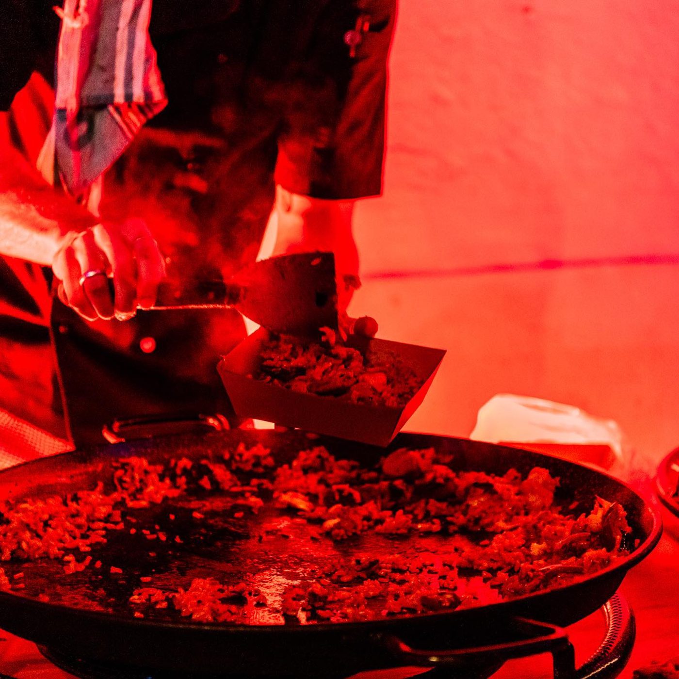 Cooking paella under red event lighting
